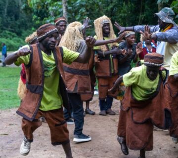 Batwa elders performing traditional dance in a forest clearing, showcasing rich cultural heritage and ancestral forest traditions 