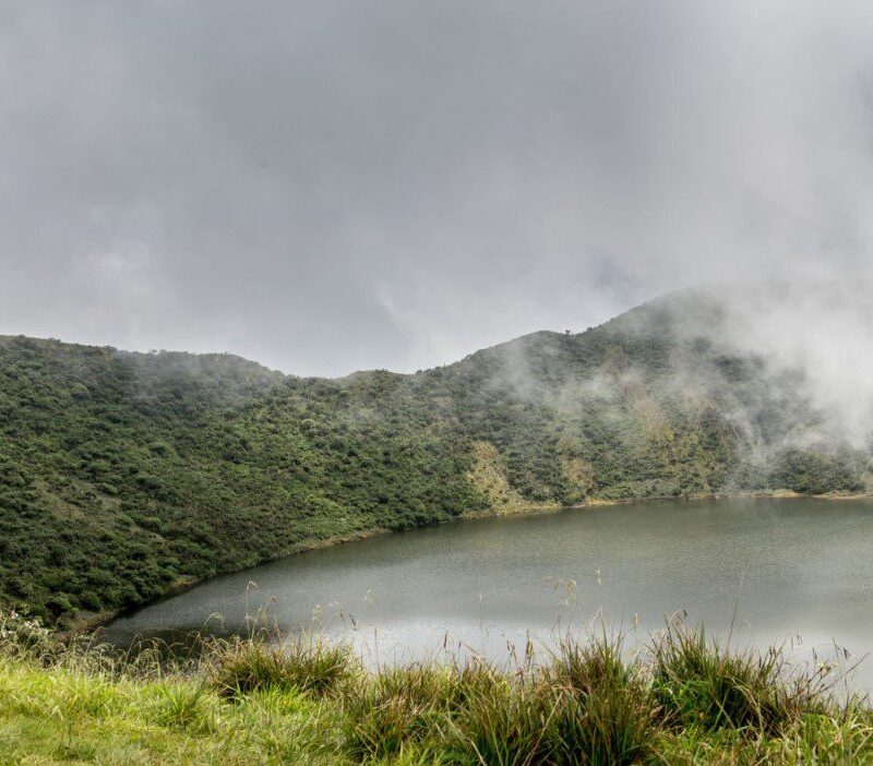 Lake-inside-Bisoke-volcano-crater Scenic view of Mount Bisoke in Rwanda’s Volcanoes National Park with lush greenery and volcanic landscapes
