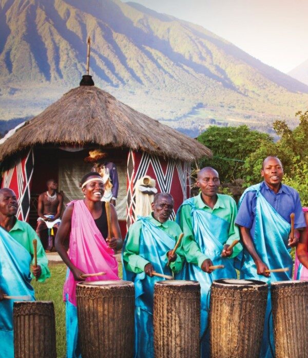Rwandan locals engaging in traditional dance, demonstrating respect for elders, and wearing modest clothing in a vibrant cultural setting."