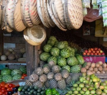 Bustling local market in Tanzania with colorful stalls and vibrant street vendors interacting with shoppers