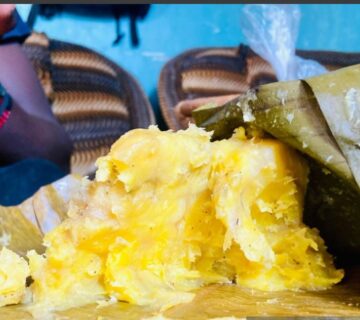 Traditional Ugandan matoke dish served with rich groundnut sauce on a banana leaf plate 