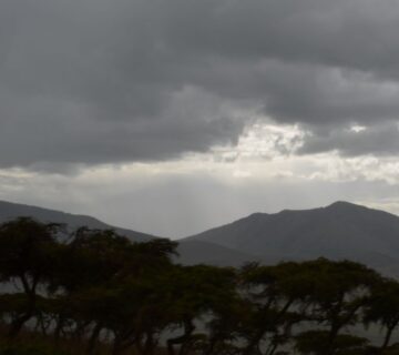 Snow capped Mount Kilimanjaro towering above the clouds in Tanzania, with rugged slopes and scenic landscapes 