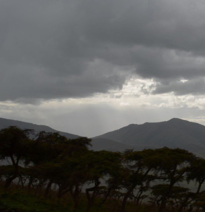 Snow-capped Mount Kilimanjaro towering above the clouds in Tanzania, with rugged slopes and scenic landscapes.