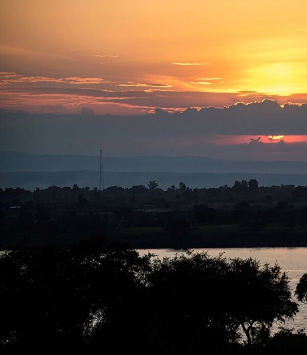 ChatGPT said: Angler fishing at night on a serene Ugandan lake under a starry sky.