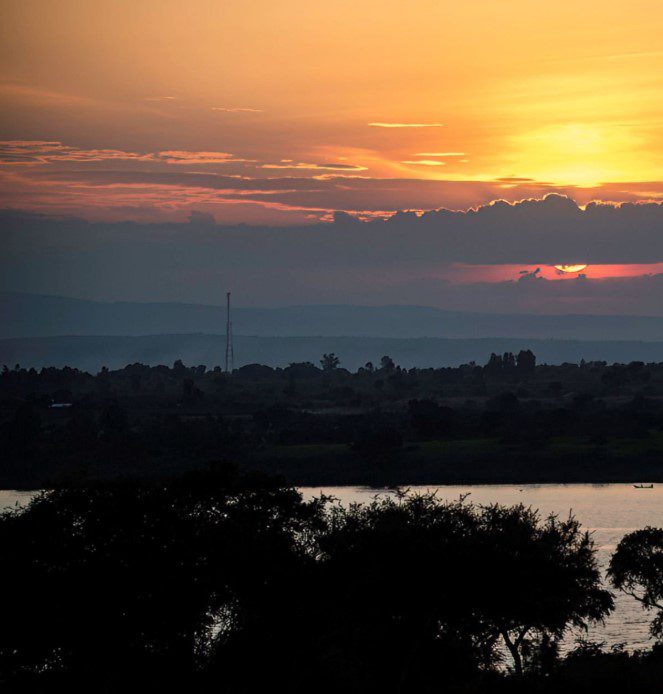 ChatGPT said: Angler fishing at night on a serene Ugandan lake under a starry sky.
