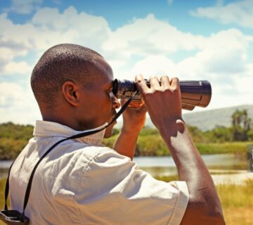 Experienced Rwanda tour guide leading a group through lush greenery in a national park 