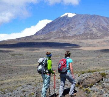 Two women hiking together on a scenic mountain trail, enjoying the breathtaking view and fresh air 