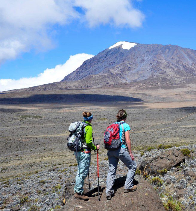 Two women hiking together on a scenic mountain trail, enjoying the breathtaking view and fresh air.