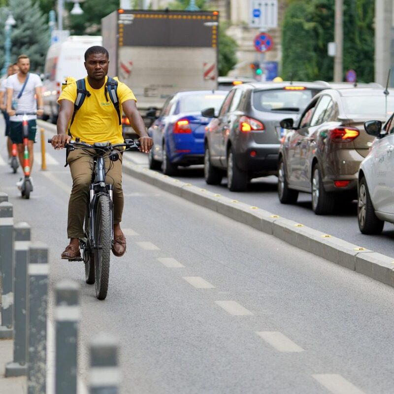 "Tourists enjoying a scenic bike ride through a vibrant city, exploring local landmarks and experiencing the culture on two wheels