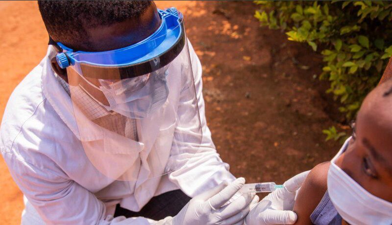 A healthcare professional administering an injection to prevent malaria in a patient.