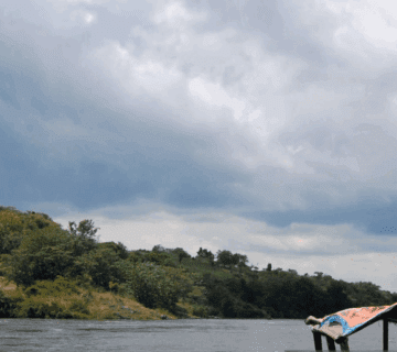 Rafting through Nile rapids at golden hour, sunlight glistening on water.