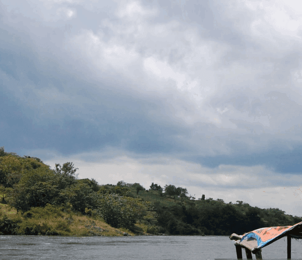 Rafting through Nile rapids at golden hour, sunlight glistening on water.