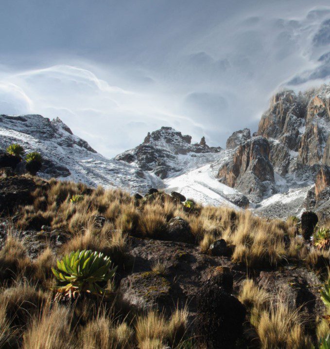 A stunning sunrise over Mount Kenya, with vibrant colors lighting up the peaks and surrounding landscape.