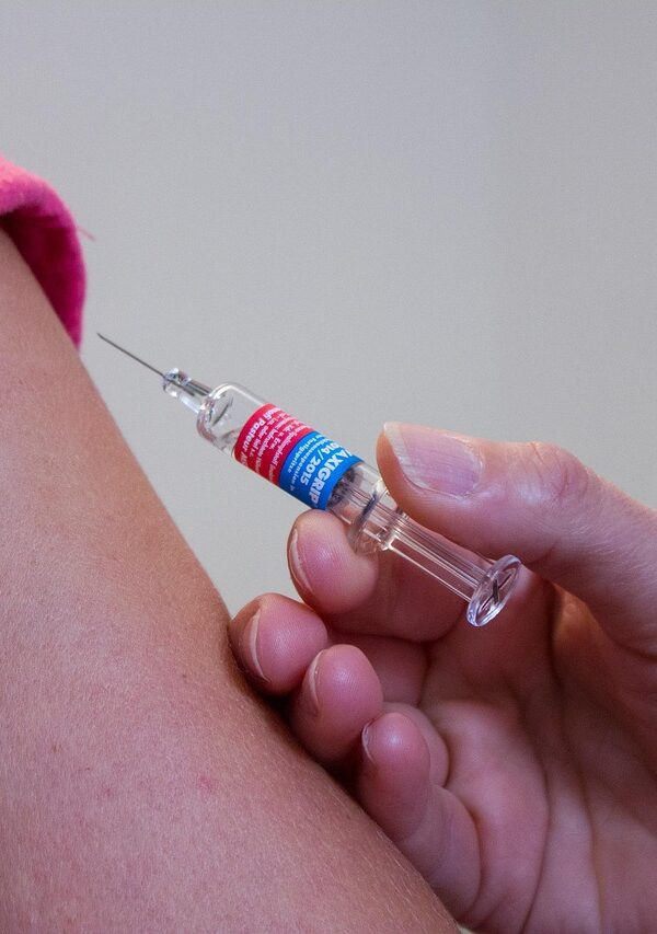Woman receiving vaccination shot before traveling to Tanzania