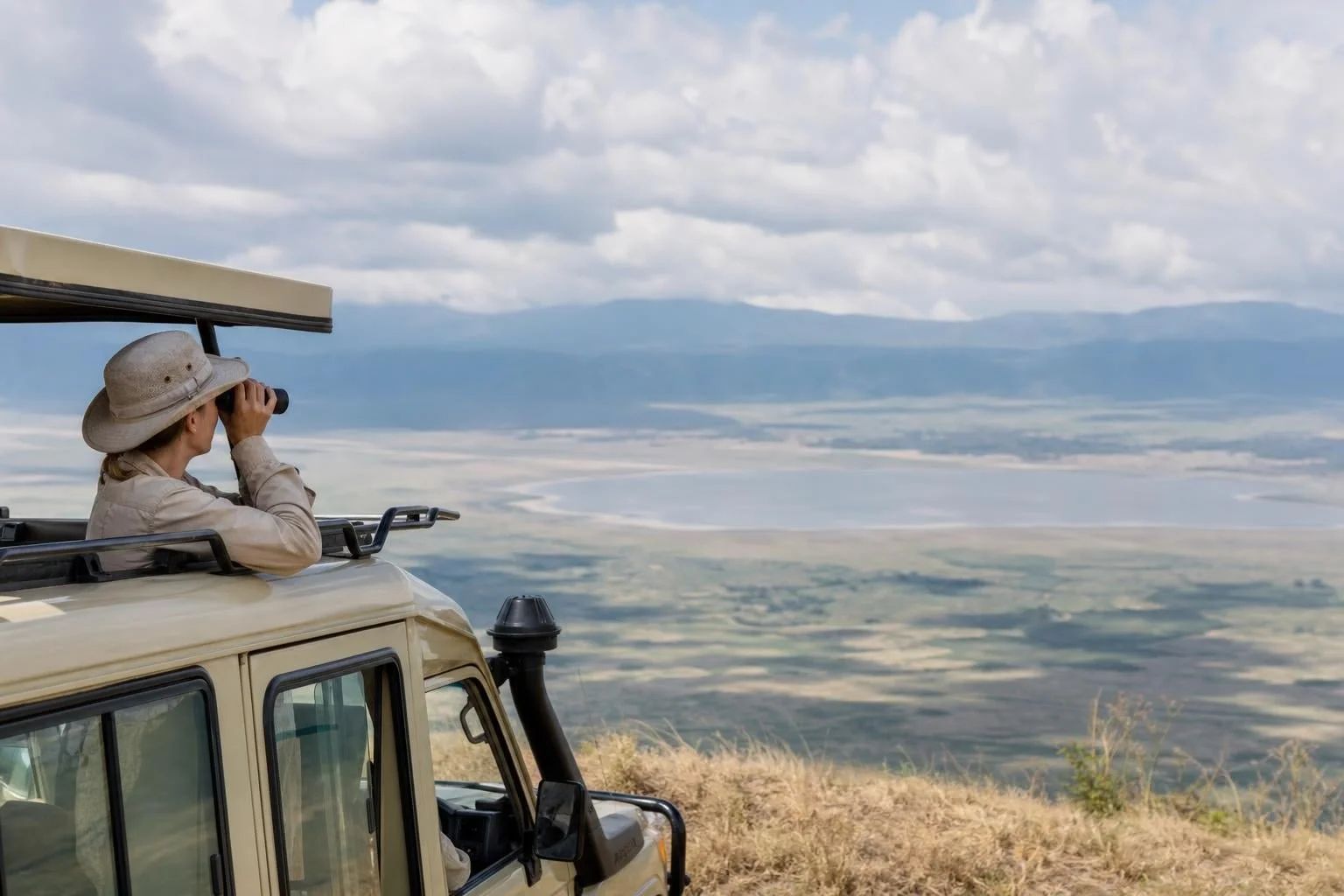 Safari travelers sharing a vehicle while exploring Ngorongoro Crater wildlife and stunning landscapes together.