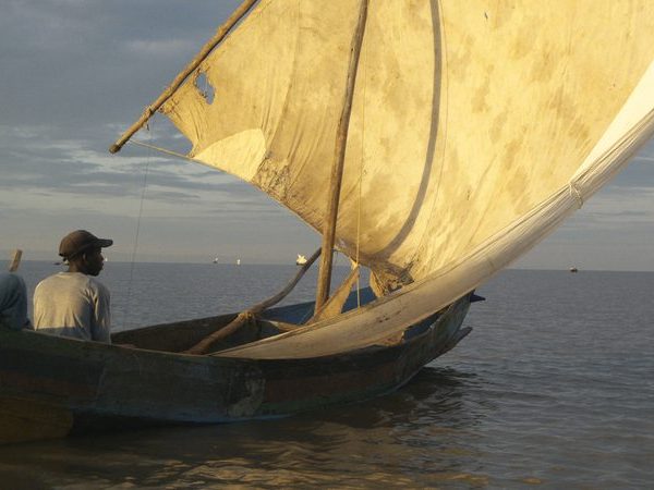 Local fishermen on a traditional sailboat at sunset on Lake Victoria