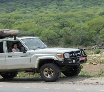 A four wheel drive self drive safari vehicle parked along a rural road