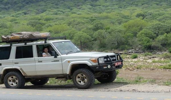 A four wheel drive self drive safari vehicle parked along a rural road