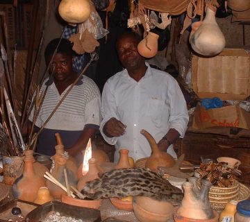Local artisans at a traditional Ugandan craft market with handmade pottery and goods