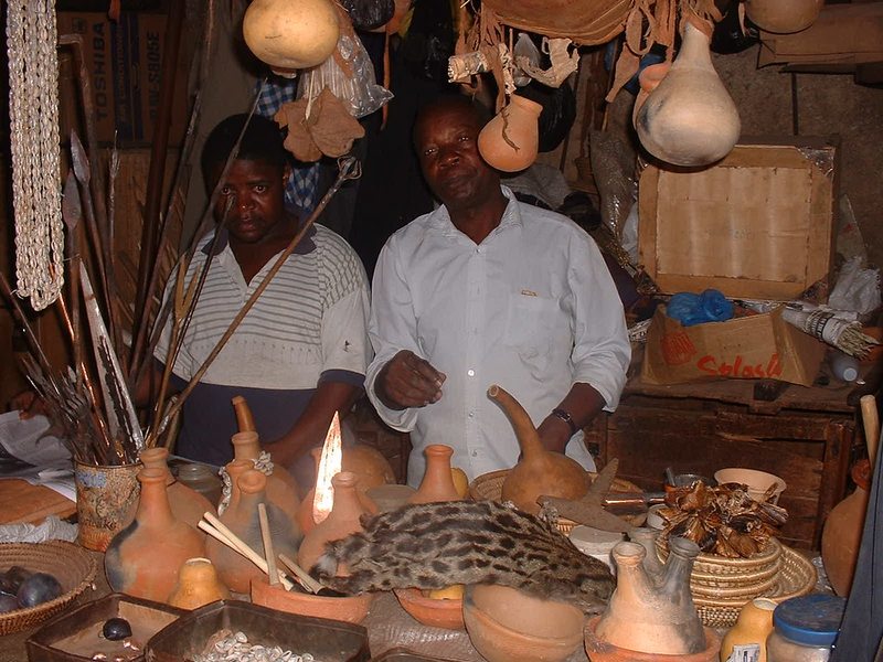 Local artisans at a traditional Ugandan craft market with handmade pottery and goods