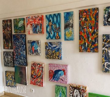 Andan contemporary artist working on a colourful canvas at Inema Arts Center in Kigali 