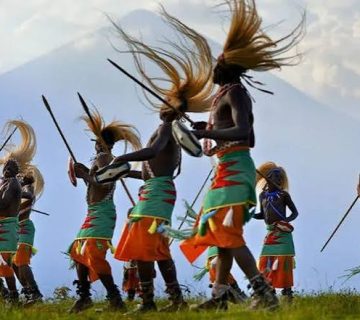Traditional Intore dancers wearing flowing warrior headdresses and performing energetic movements during a cultural celebration in Rwanda 
