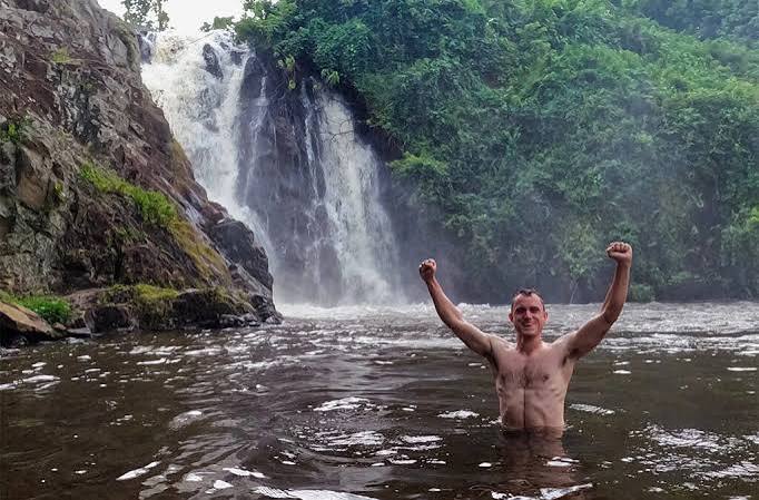 Sezibwa River flowing over rocky formations into a natural pool surrounded by green vegetation near Mukono, Uganda