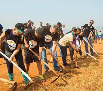 Residents participating in Umuganda community cleaning activities along a neighbourhood street in Kigali 